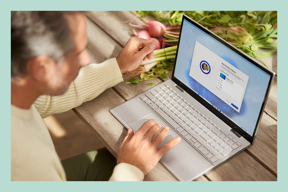 Un hombre con un ordenador portátil configura archivos, aplicaciones y configuraciones predeterminadas existentes a través de Windows 11.